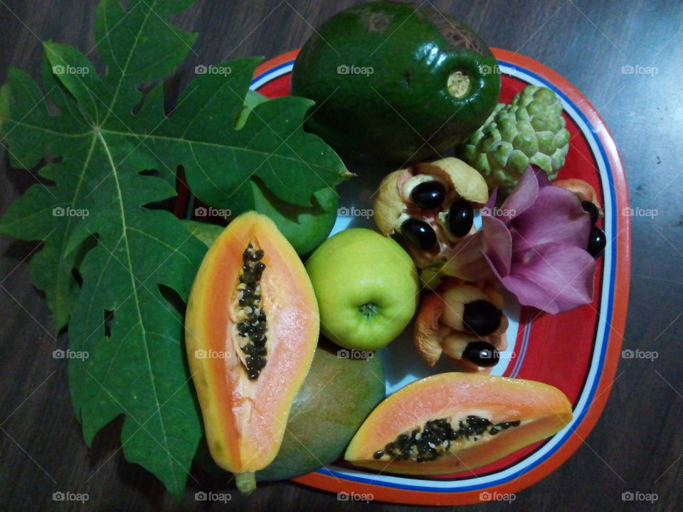array of Jamaican fruits. displayed are papaya, apple.,ackee, avocado pears.  sweet sap