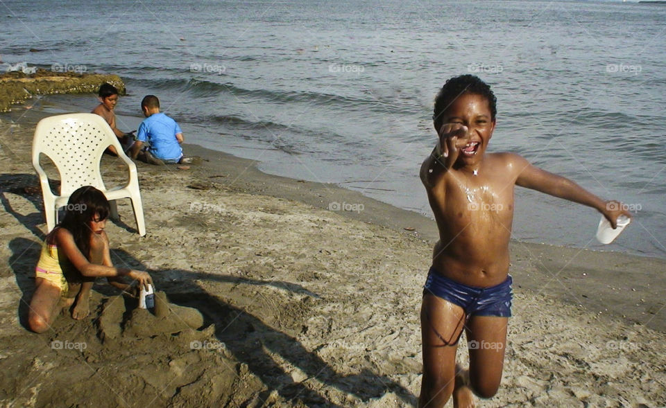 Happy boy running on sandy beach