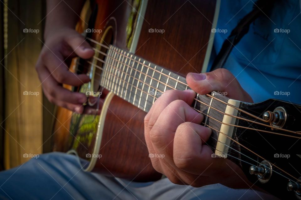 Strumming away on the guitar. 