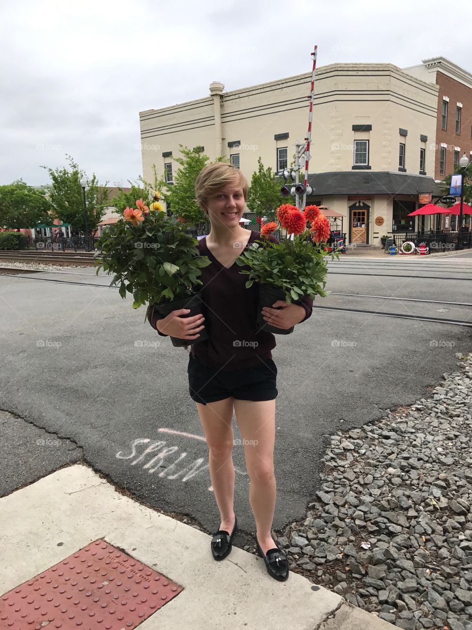A young woman poses by the train station of Old Town Manassas, Virginia with freshly-bought Dahlias from the local farmer’s market