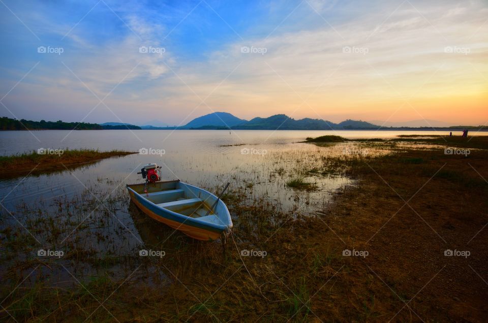 The boat docked on the lake side during beautiful golden sunset at Kwong Lake,  Rantau panjang,  Kelantan.