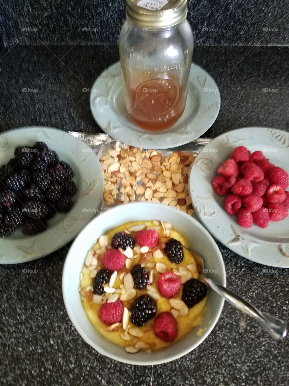 healthy breakfast. Coarsely ground polenta with fresh honey, fresh blackberries, fresh raspberries and toasted sliced almonds.