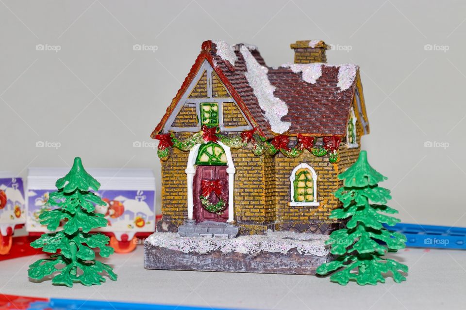 A toy house with trees decorated for Christmas 