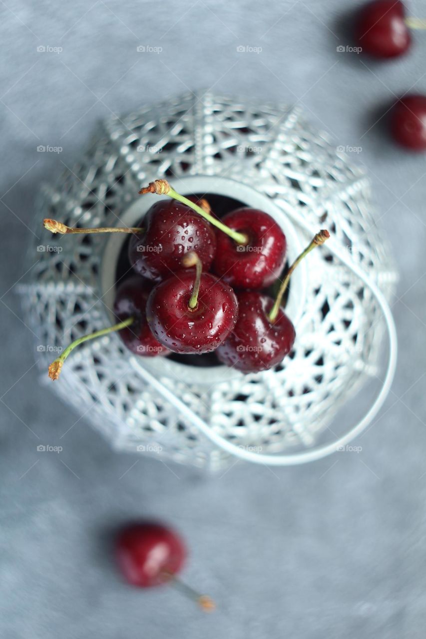 Fresh cherries in a grey vase