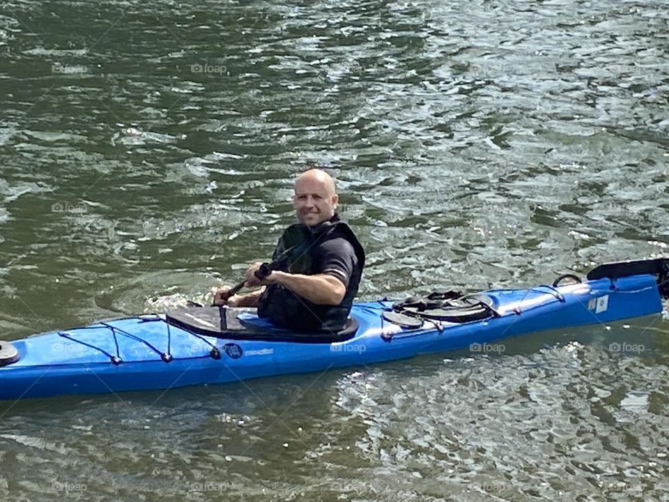 A friend kajaking in the waters of the East River at Newtown Creek in Long Island City, Queens, NY photographed on an early August afternoon in 2021. Hypnotic Productions