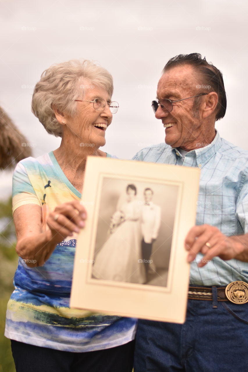 Senior couple holding their wedding photo
