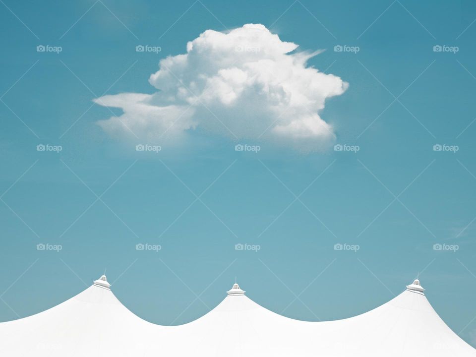 A single cloud hovering above white tent structure