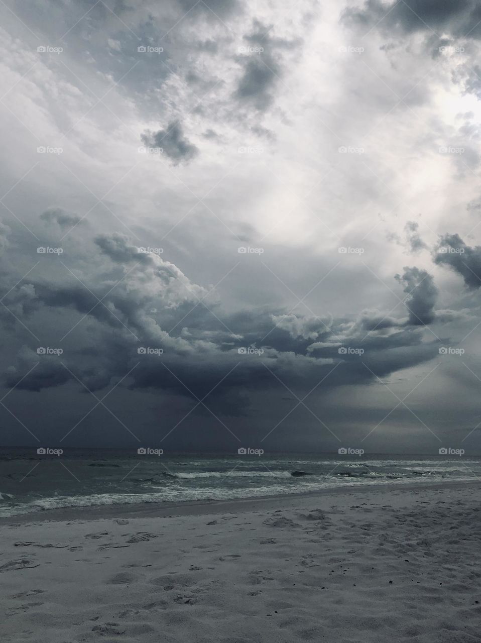 Storm clouds darken the day on the beach, threatening rain and more