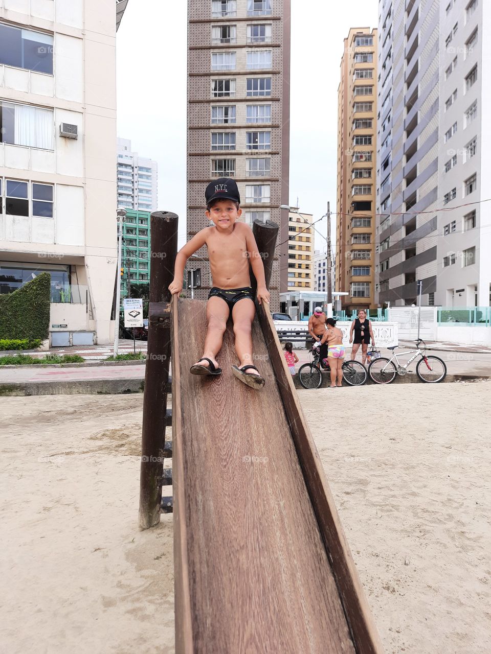 cute boy in a cap on the slide in Santos