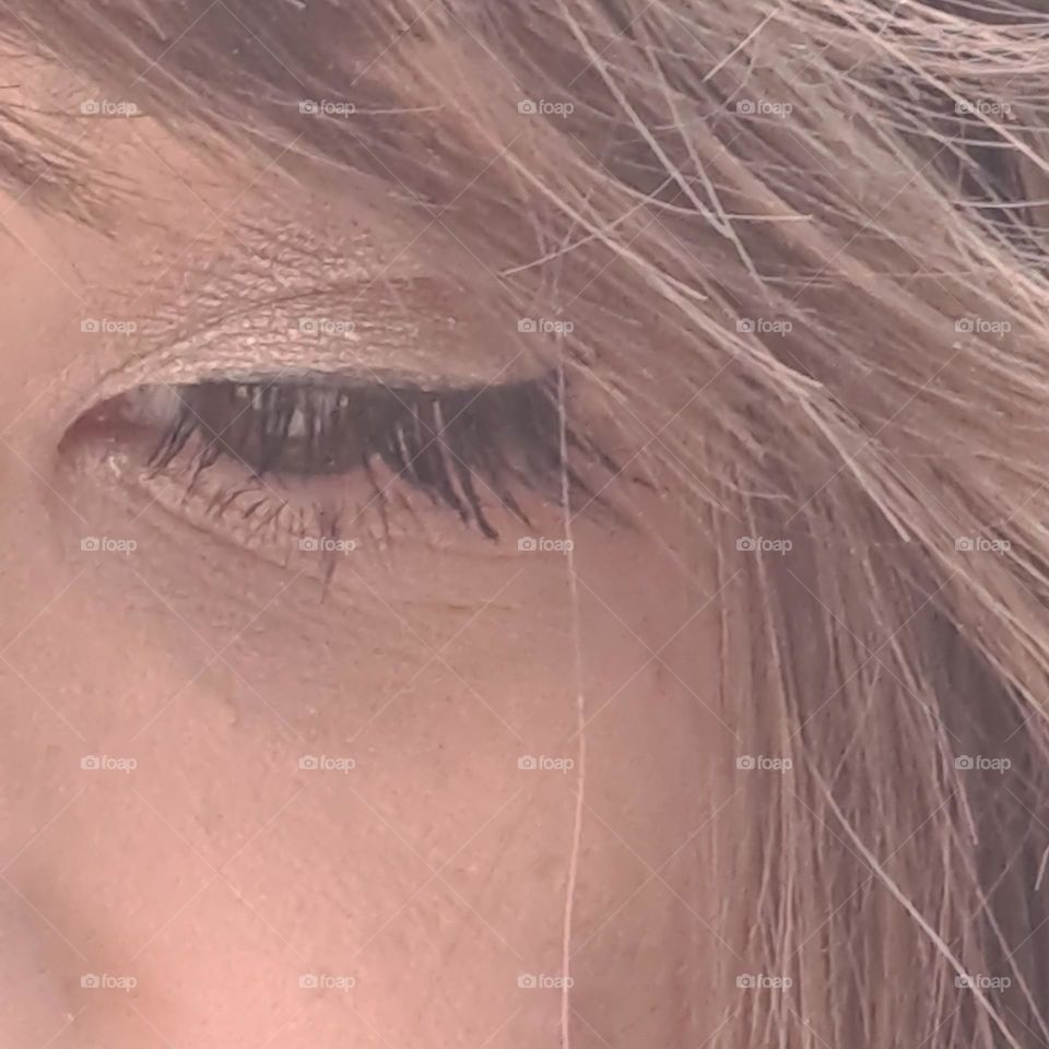 ladies eye and lashes under swept back fringe. part of face. soft