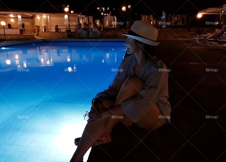 One young woman near the pool in the night.