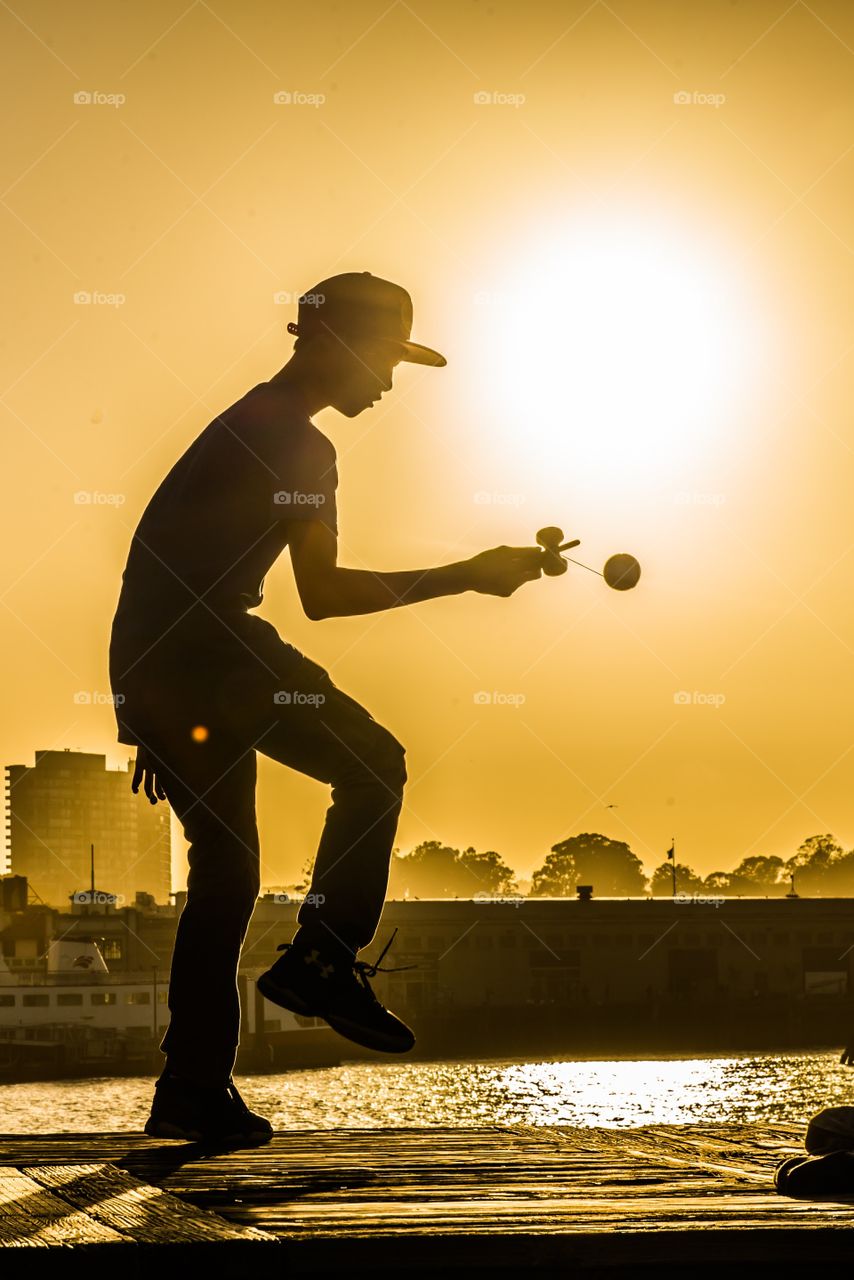 Silhouette of boy playing with yoyo toy
