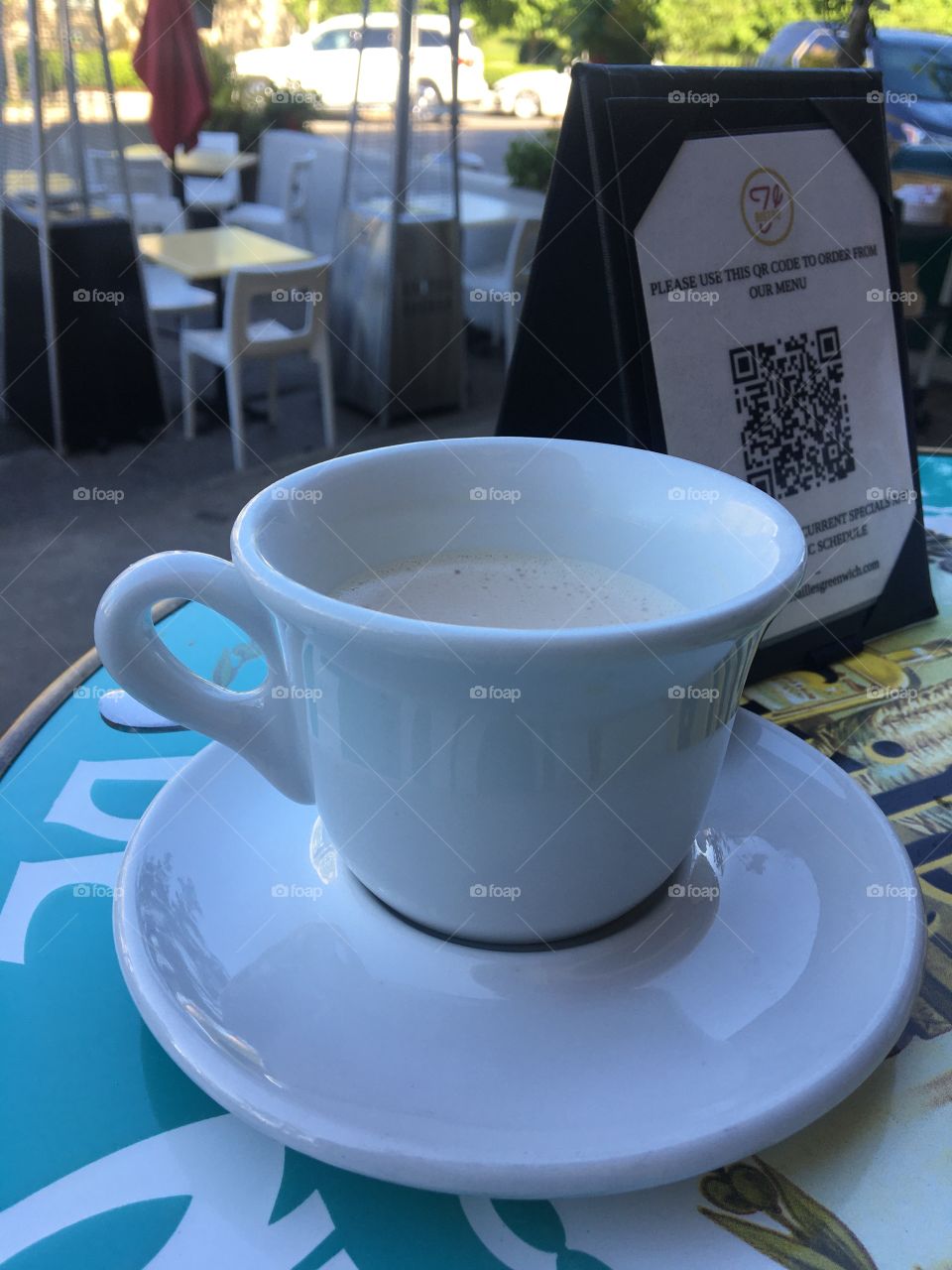 Chai latte in white mug at Bistro V in Greenwich, Connecticut, with QR code menu in background as coronavirus pandemic winds down 