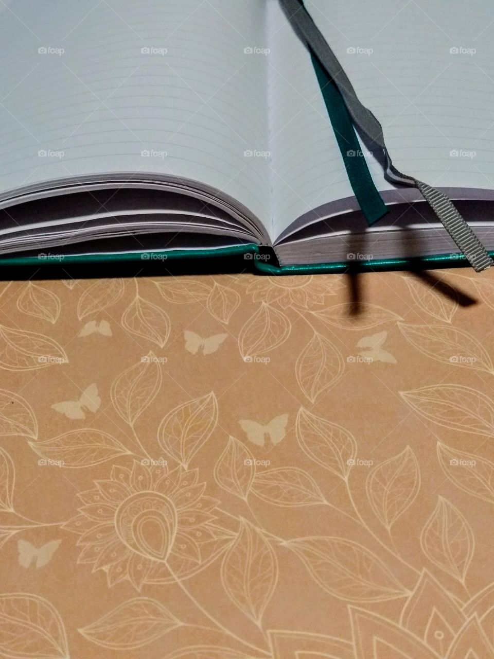 green bookmarked open journal/diary on pink patterned background