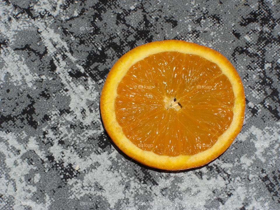 Fresh orange on a stone plate.