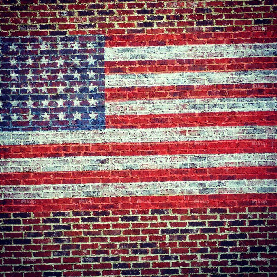 The American Flag painted on a brick wall.