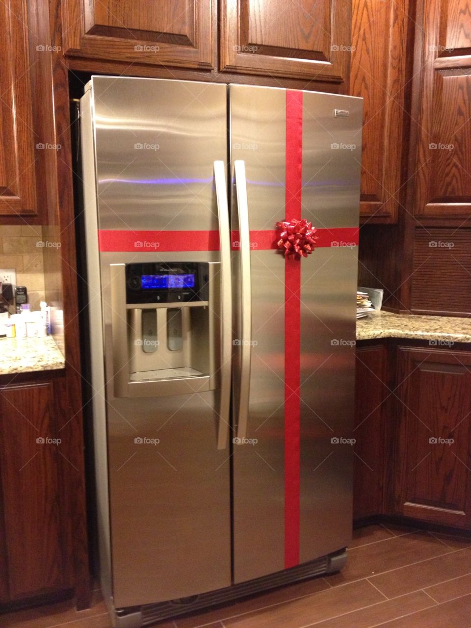 Kitchen Christmas decor. Bow tied around stainless steel refrigerator for Christmas decor.