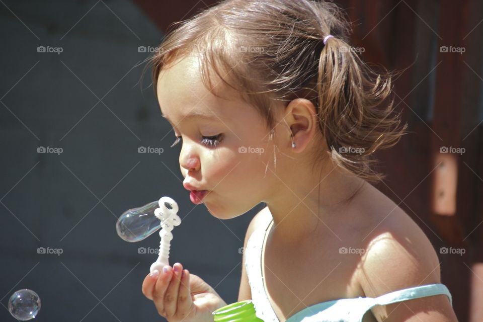 Cute girl blowing bubbles