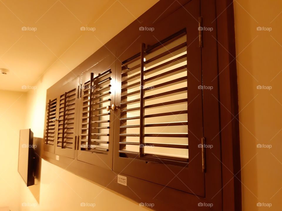 Plantation window in a hotel room. Provided for good air circulation.