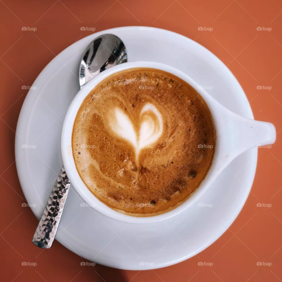 Coffee cup on the table with coffee and a latte art heart