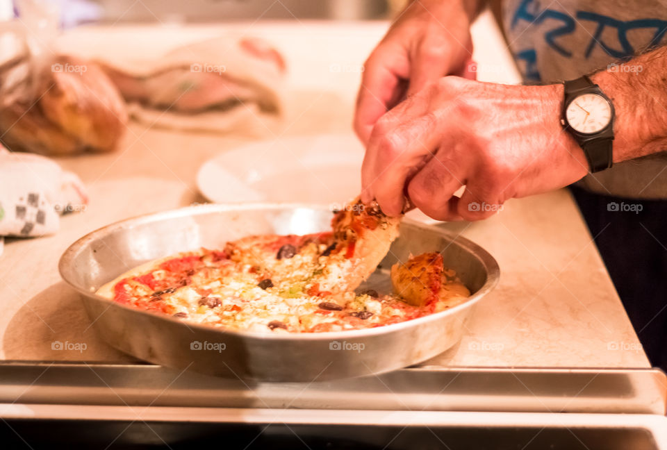 Hand taking pizza slice