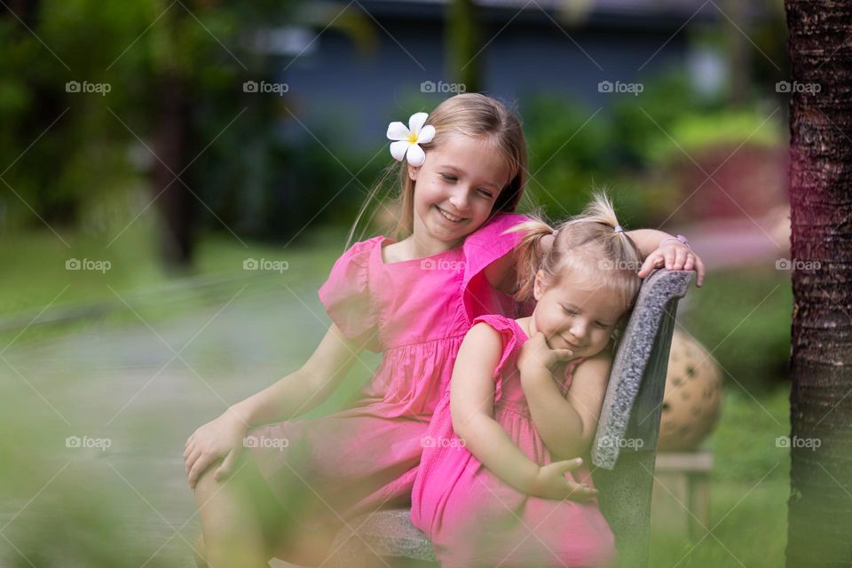Two sisters in pink dresses outdoor