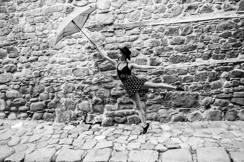 Ballerina posing with umbrella on the street as Mary Poppins