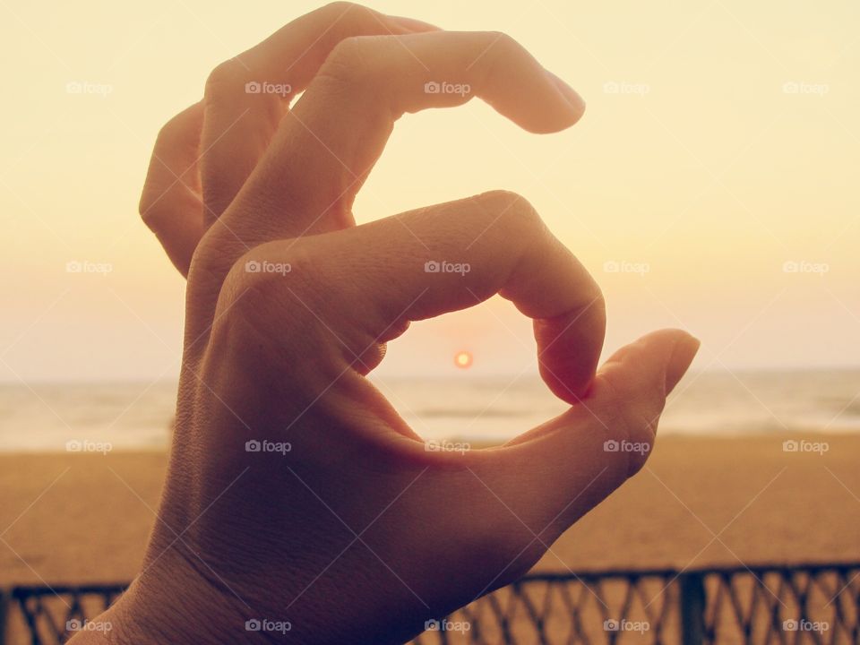 Gesture of hand during sunset