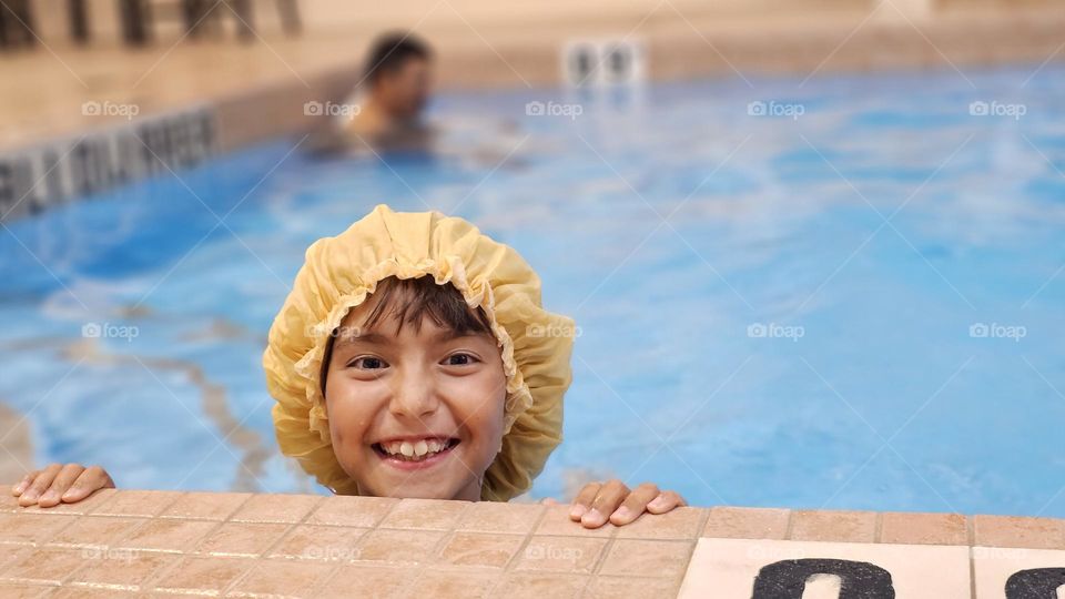 Happy cute girl in a swimming pool