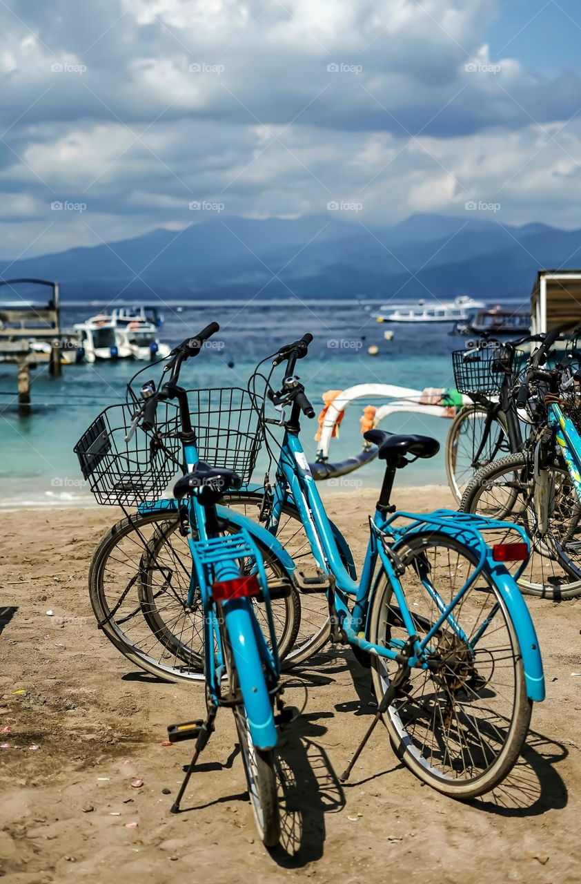 twin blue bicycles alongside a magnificent and beautiful beach