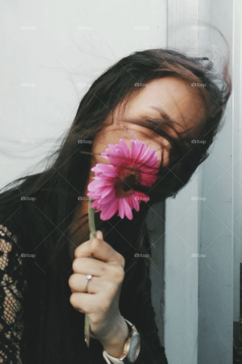 This photo is classic and beautiful for me. The wind accentuate the hair of my friend. The flower adds color to it. The black and white colors give some mystery vibe. It could relate to a poetry, importance, love, mystery and etc.