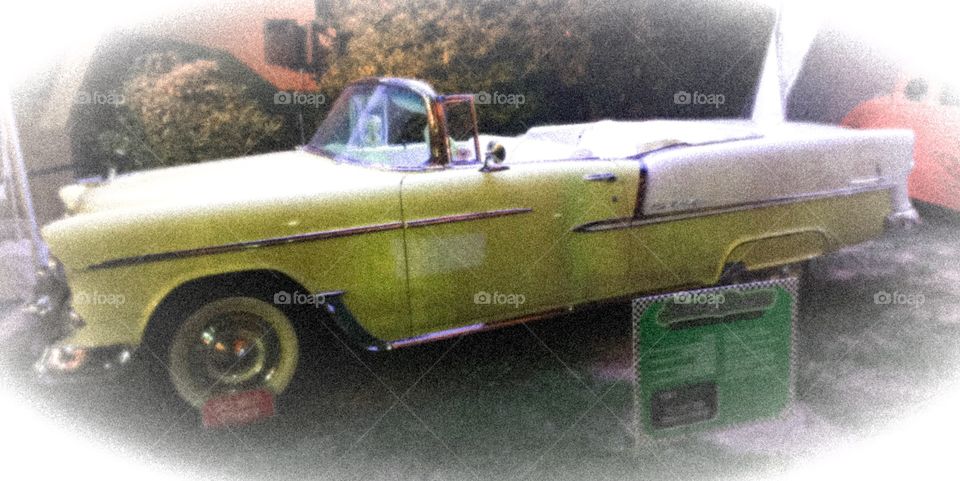 Vintage Chevrolet Belair with drop top and white wall tires in a vintage filter