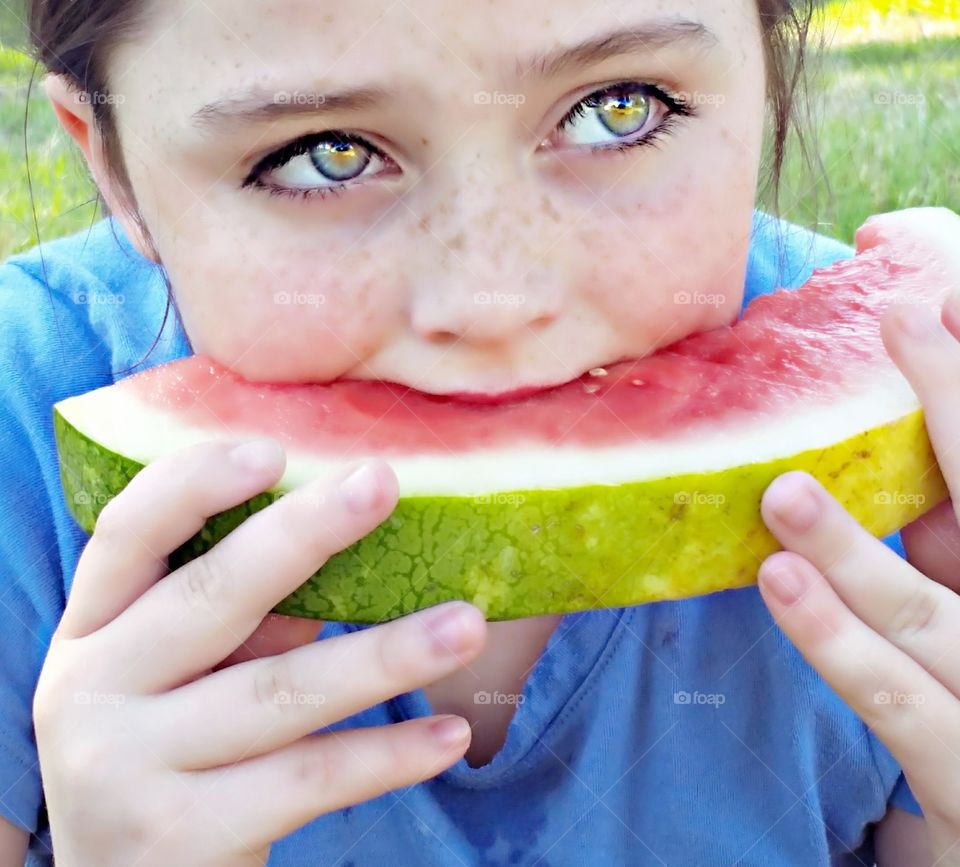 girl with beautiful eyes eating watermelon