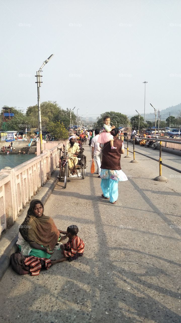 different situation of Two childrens. One was happy nd sitting in shoulders nd Second Was sitting in the road