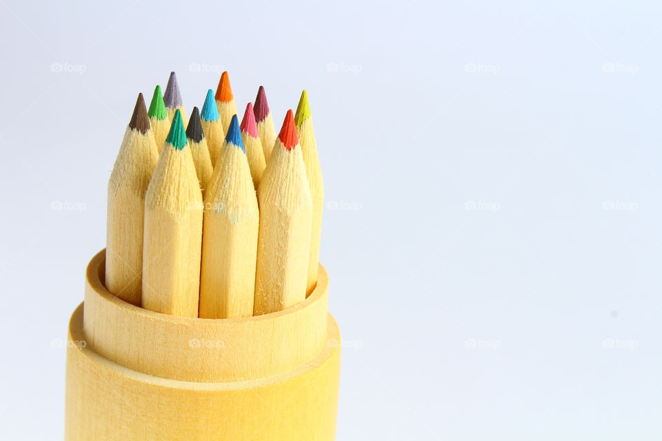 Group of color crayons in a wooden cylinder isolated macro