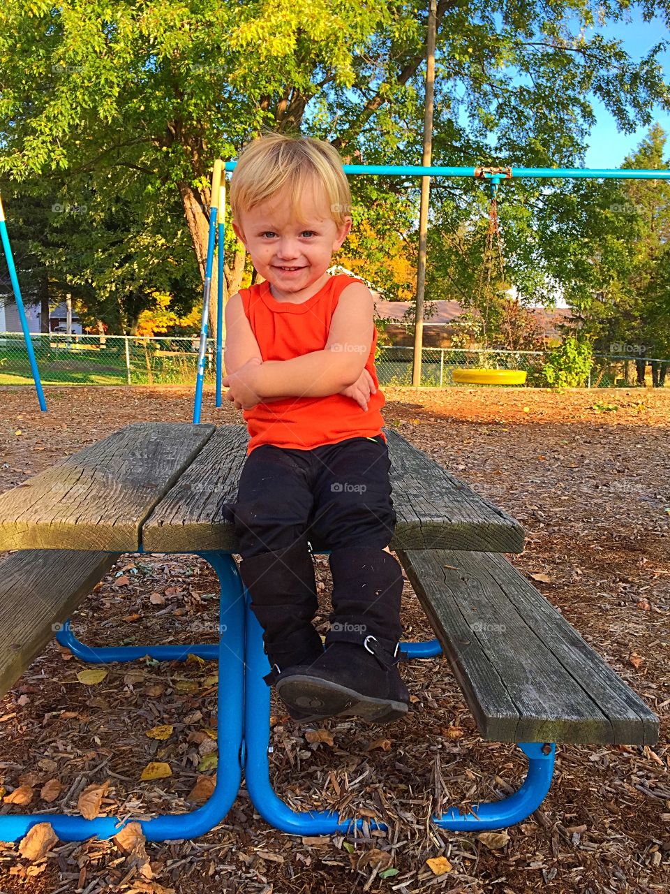 Portrait of a cute boy in park with arms folded