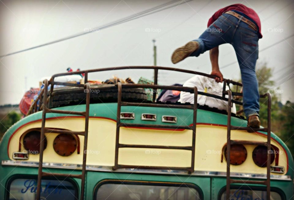 Man Loading Chicken Bus in Guatemala 