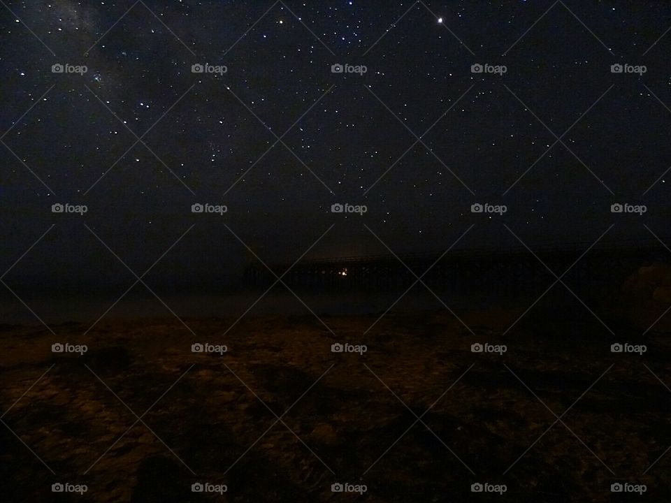 Milky Way and pier at beach