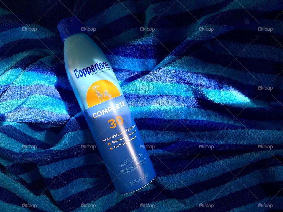 Sun protection spray Coppertone on the blue towel 