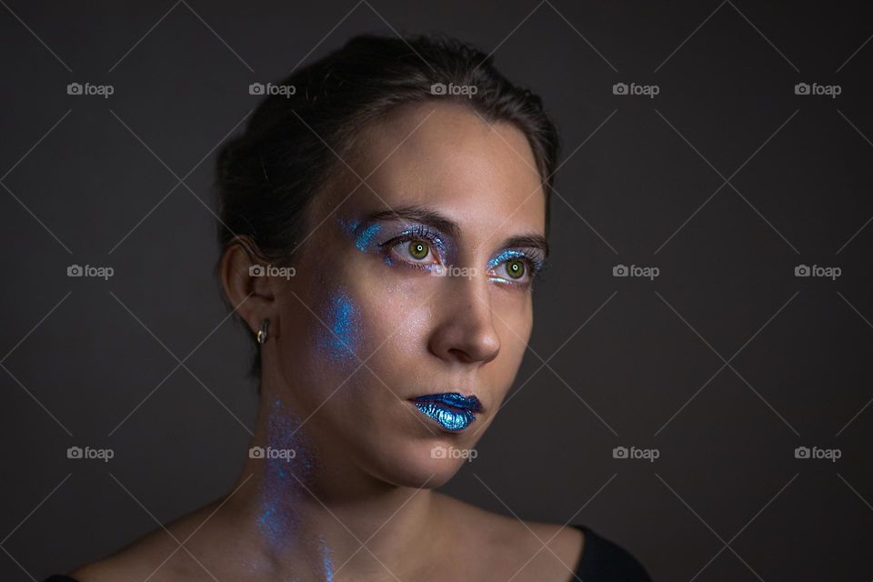 Portrait of young woman with glitter on face 