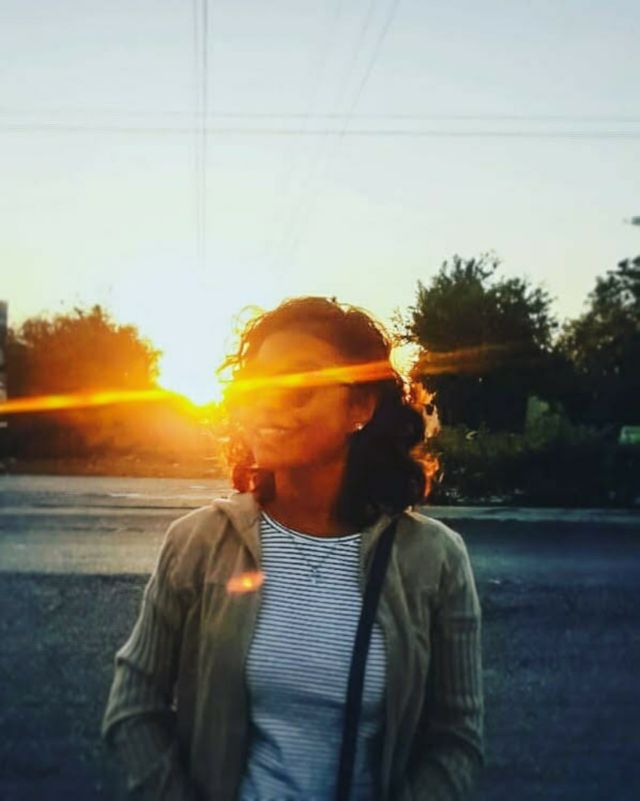 sun rays illuminating girl smiling with glasses