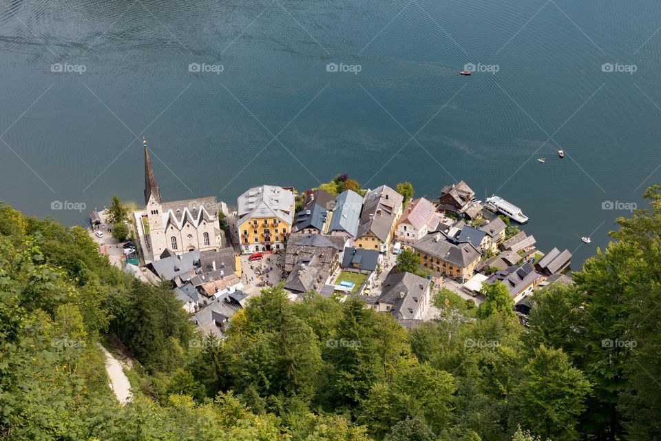 Looking down on beautiful town Hallstatt with colorful houses by the lake, shot from high above  
