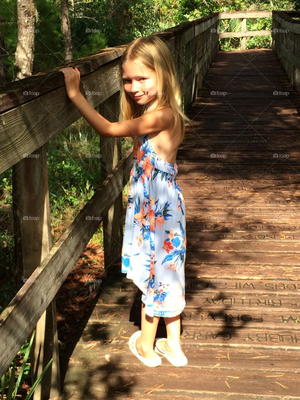 Pretty little girl posing on a path in the forest 