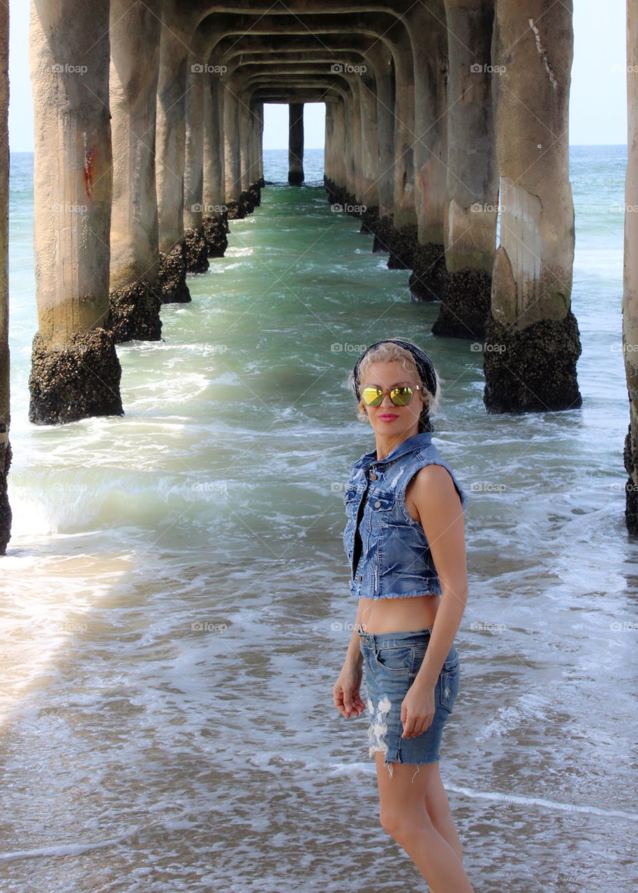 Woman standing under pier on sea
