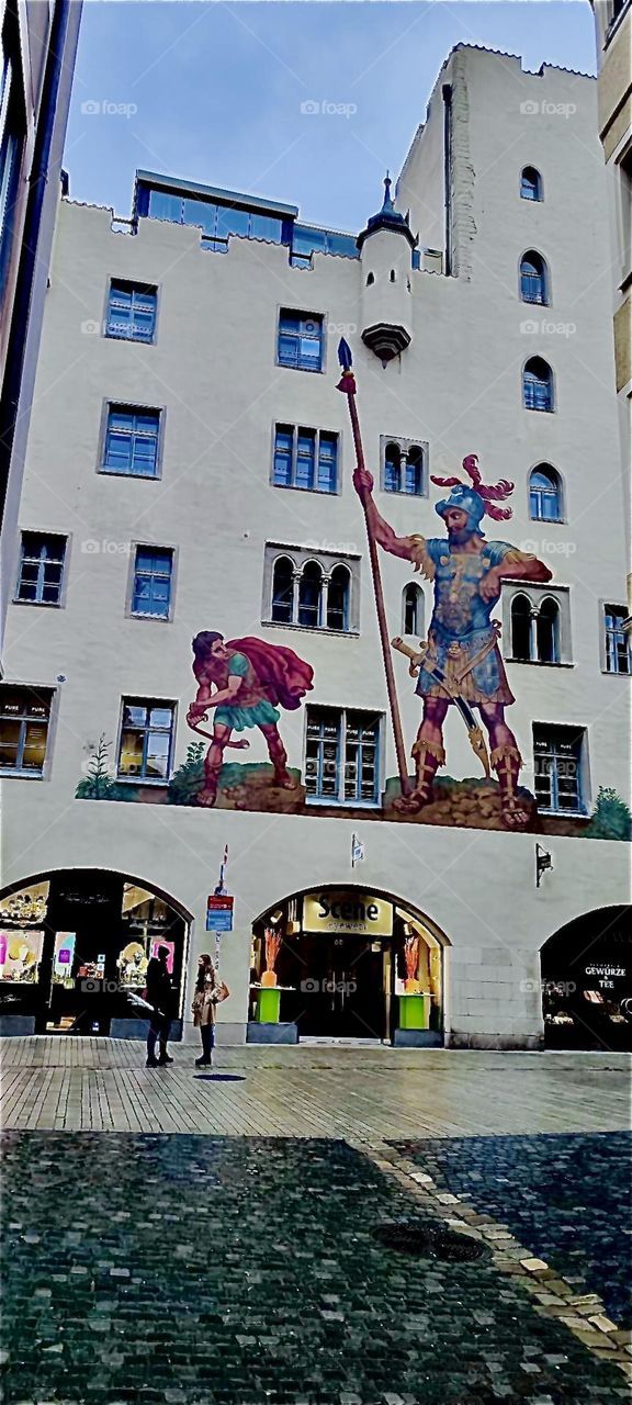 The “Goliath House” in “Regensburg”  is a gorgeous landmark house featuring the fight of “David” against the giant “Goliath”. Here he gets ready to deliver the fatal blow to the giant’s forehead using a slingshot. 2023. Hypnotic Productions