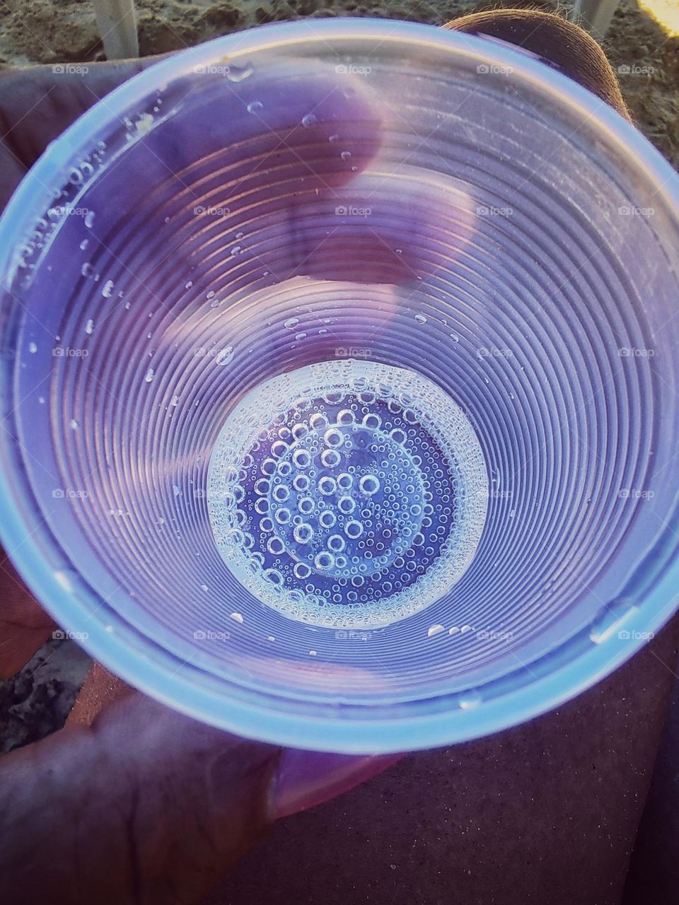 a simple plastic cup with some sparkling water.  they form at the bottom small bubbles in the shape of several circles.