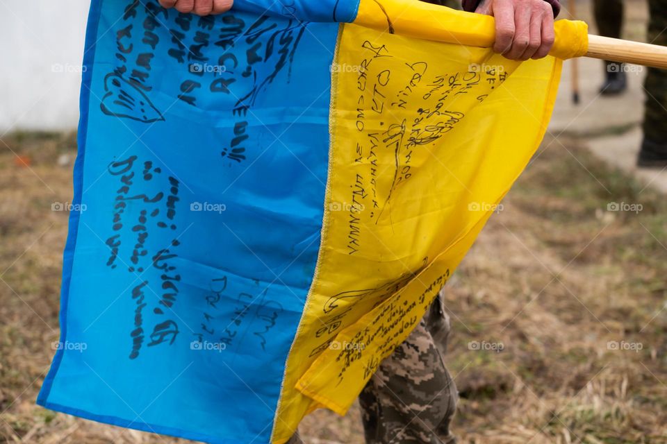 Flag of Ukraine, with wishes on it, on the battle field 