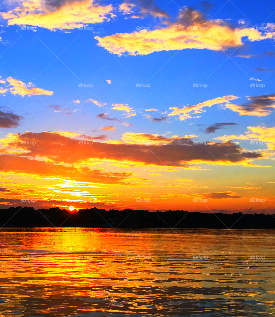 Kaleidoscope Sunset. The sky and the bay are reflective of the Suns mystical rays providing a smooth and pleasant photographic moment. mystic