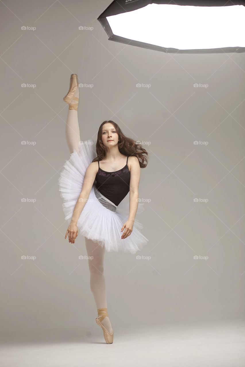 Young ballerina in a tutu doing the splits.

￼

￼