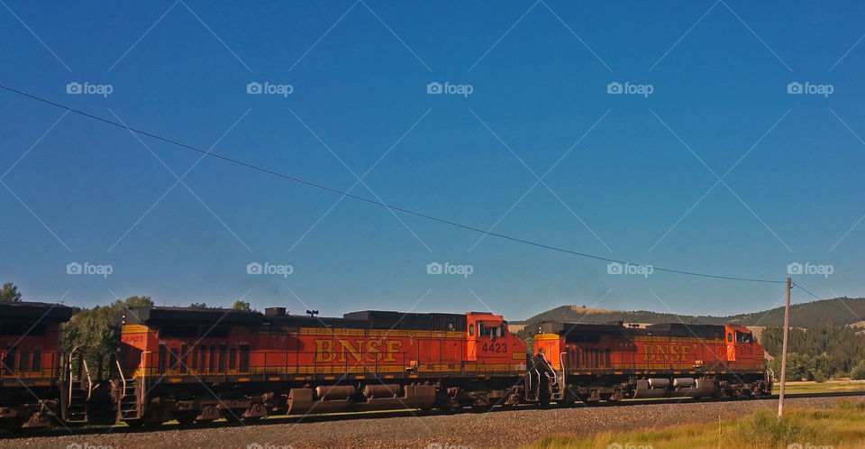 Train Engines Traveling The Tracks with blue skies